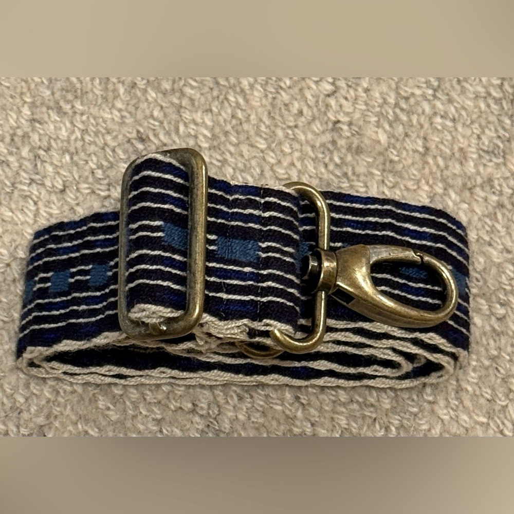 Parker Thatch handwoven crossbody strap with brass buckle latches.